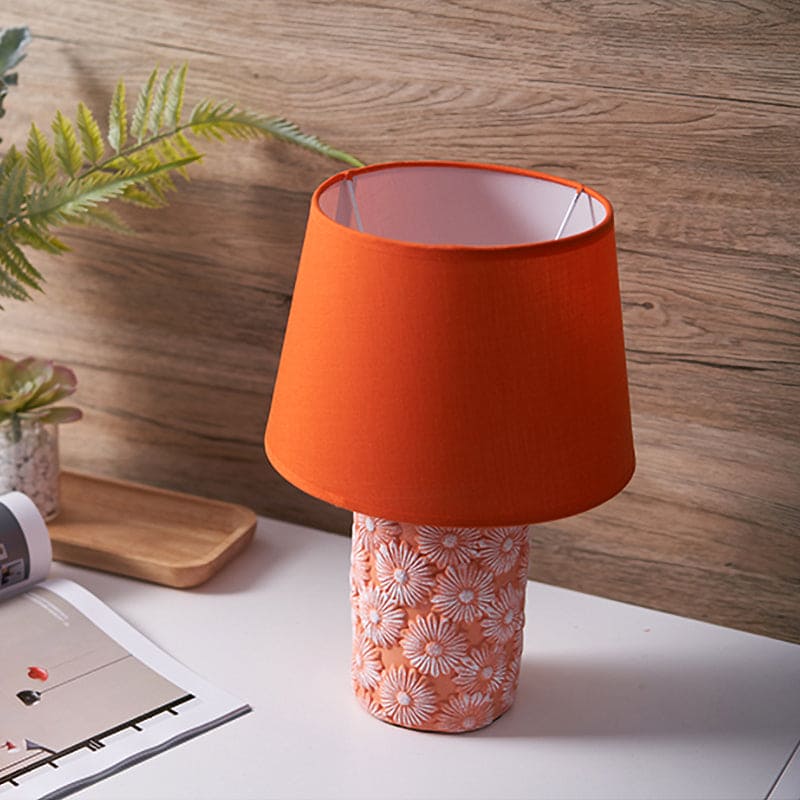 Lampe conique orange sur une table en bois
