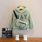 Gros plan sur la texture du pull teddy beige