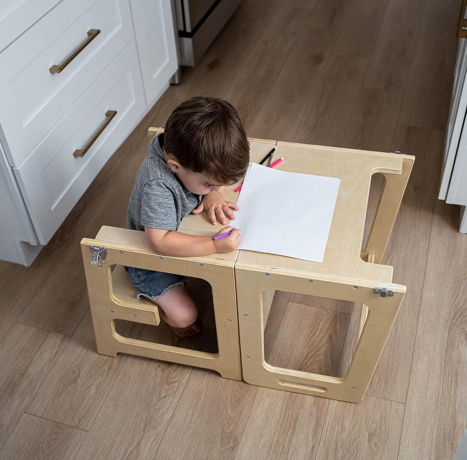 Tour d'apprentissage utilisée comme table, enfant jouant dessus