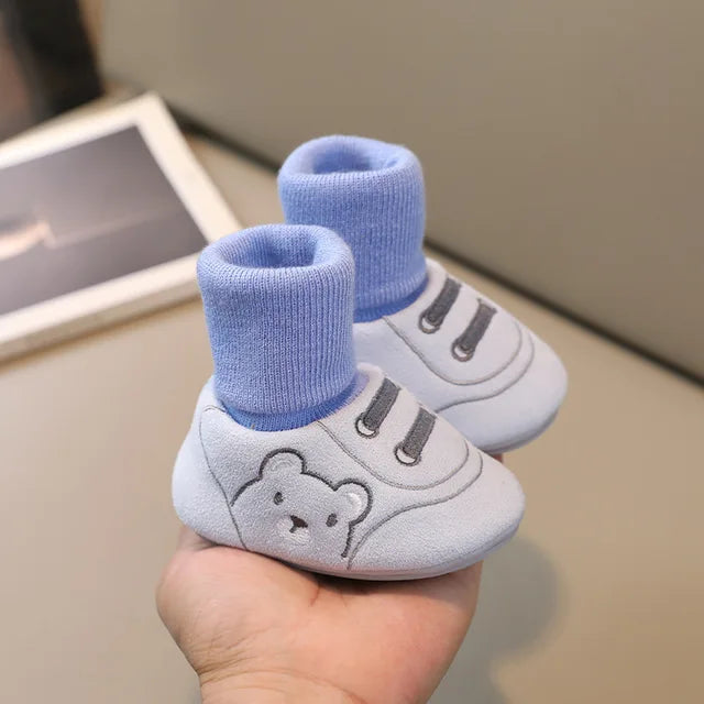 Enfant portant chaussures souples, jouant sur sol intérieur