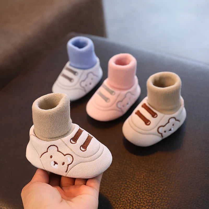 Chaussures bébé antidérapantes avec semelle souple sur sol en bois