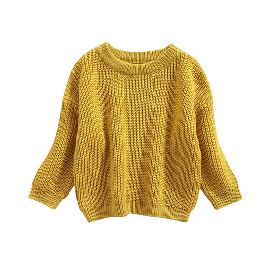 Pull bébé à motifs, présenté sur un fond neutre