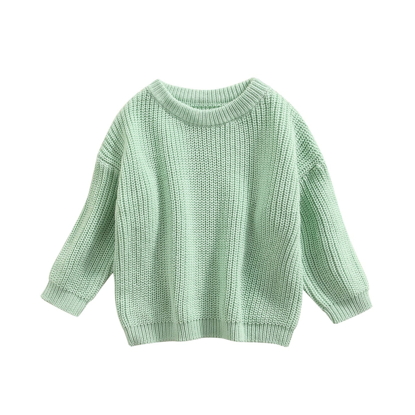 Pull d'hiver pour bébé, couleur douce, posé sur une table