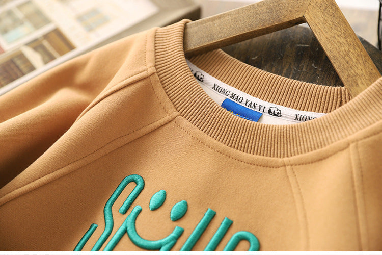 Vue de côté du pull enfant marron avec imprimé sourire