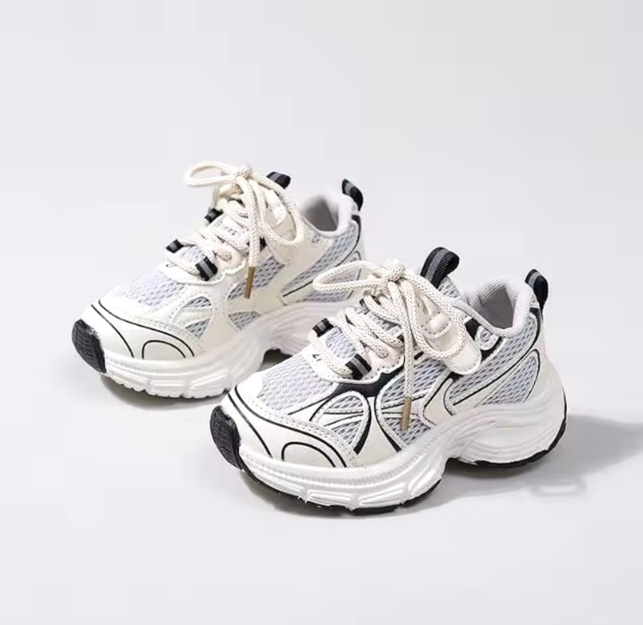 Vue latérale de baskets enfant noires et blanches respirantes