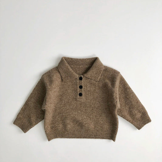 Enfant portant un polo manches longues, jouant dehors