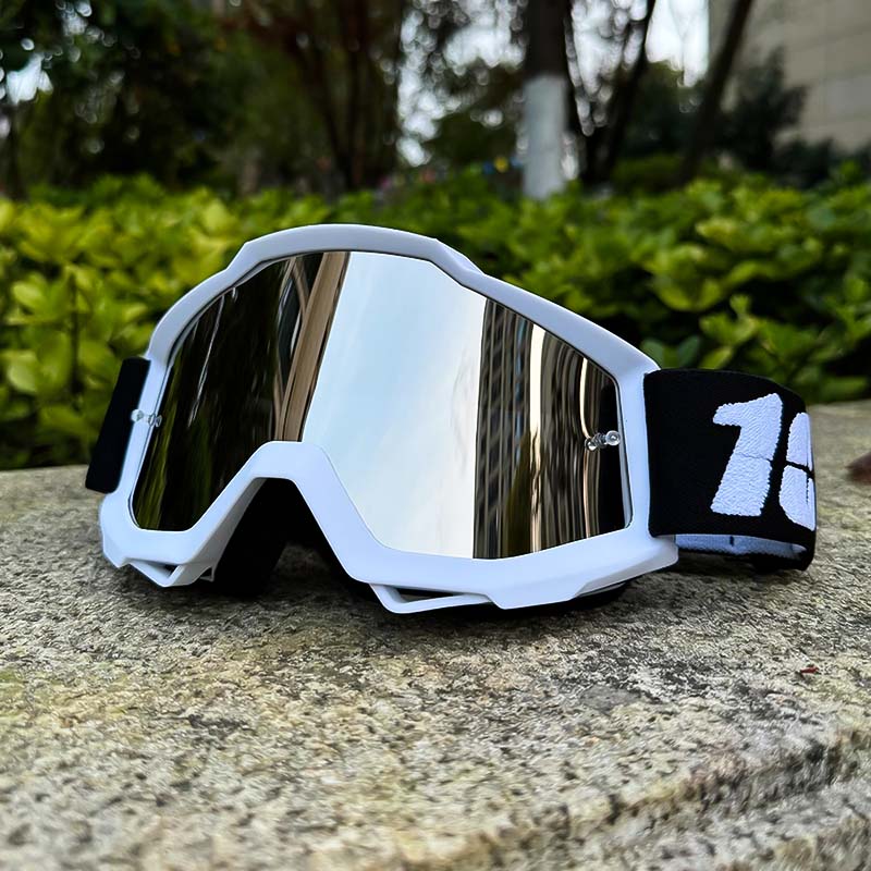 Lunettes de motocross posées sur une surface, verres réfléchissants