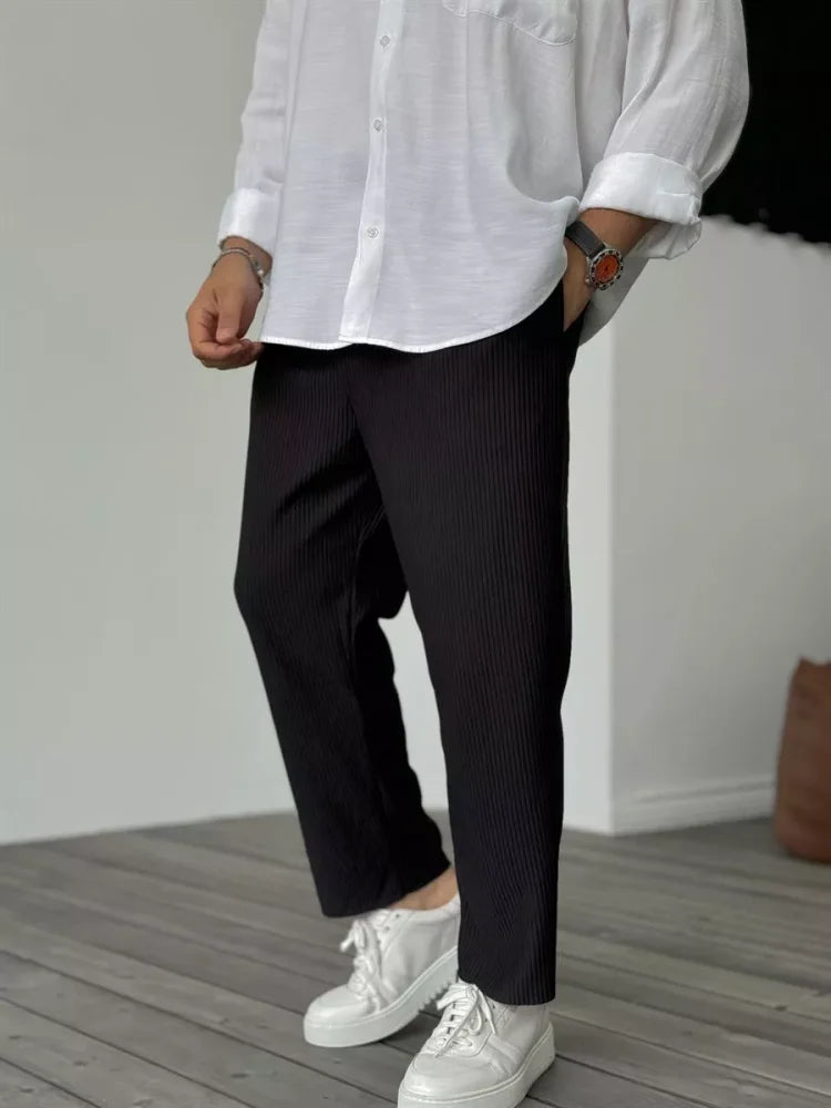 Homme assis portant un pantalon en velours côtelé gris