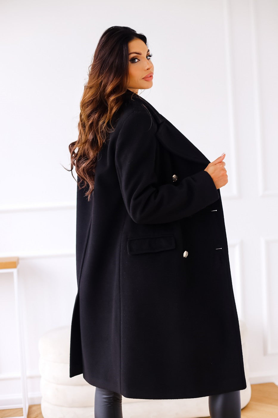 Détail des boutons dorés sur le manteau élégant et structuré