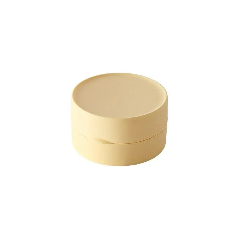 Petite boîte à savon jaune posée sur une table