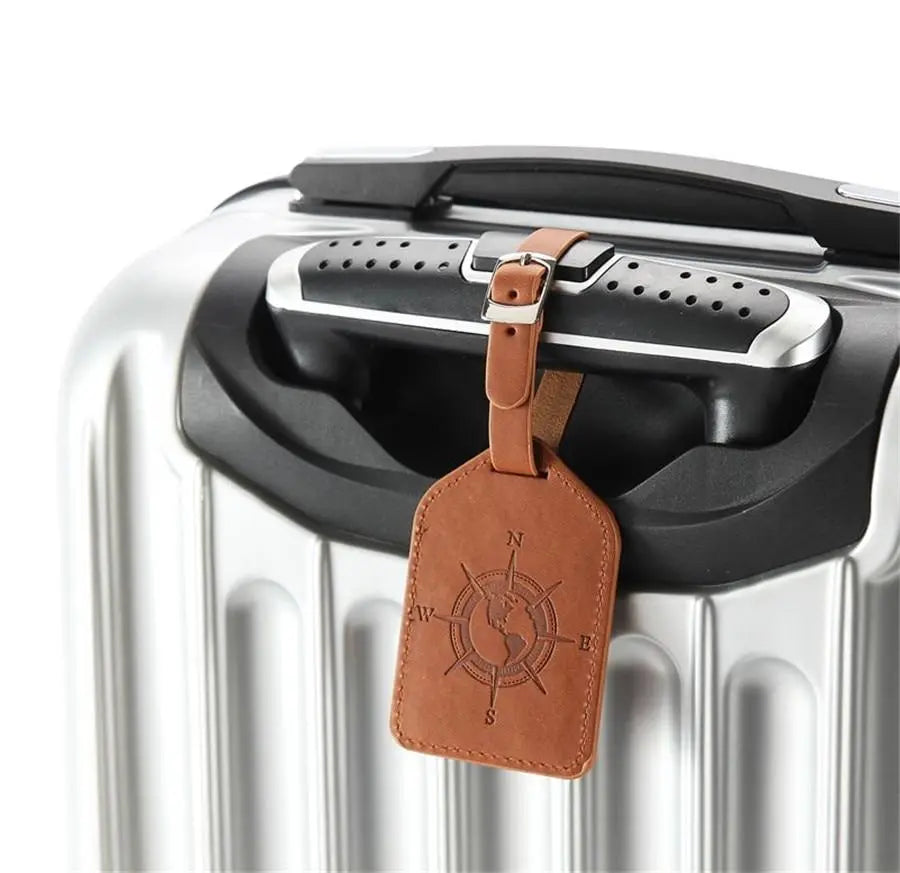 Étiquette bagage avec boussole gravée sur fond beige