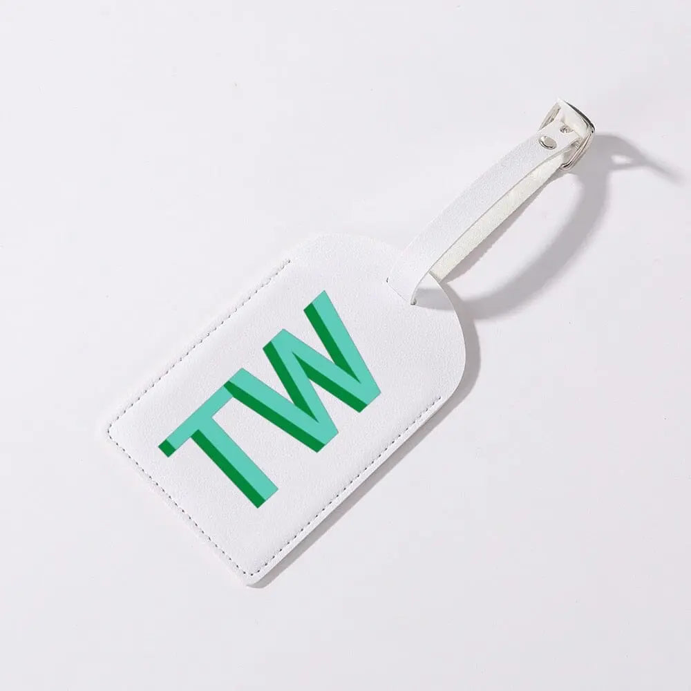 Détail d'une étiquette de bagage avec initiales sur fond vert