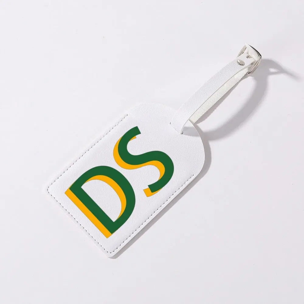 Détail d'une étiquette de bagage avec initiales sur fond gris