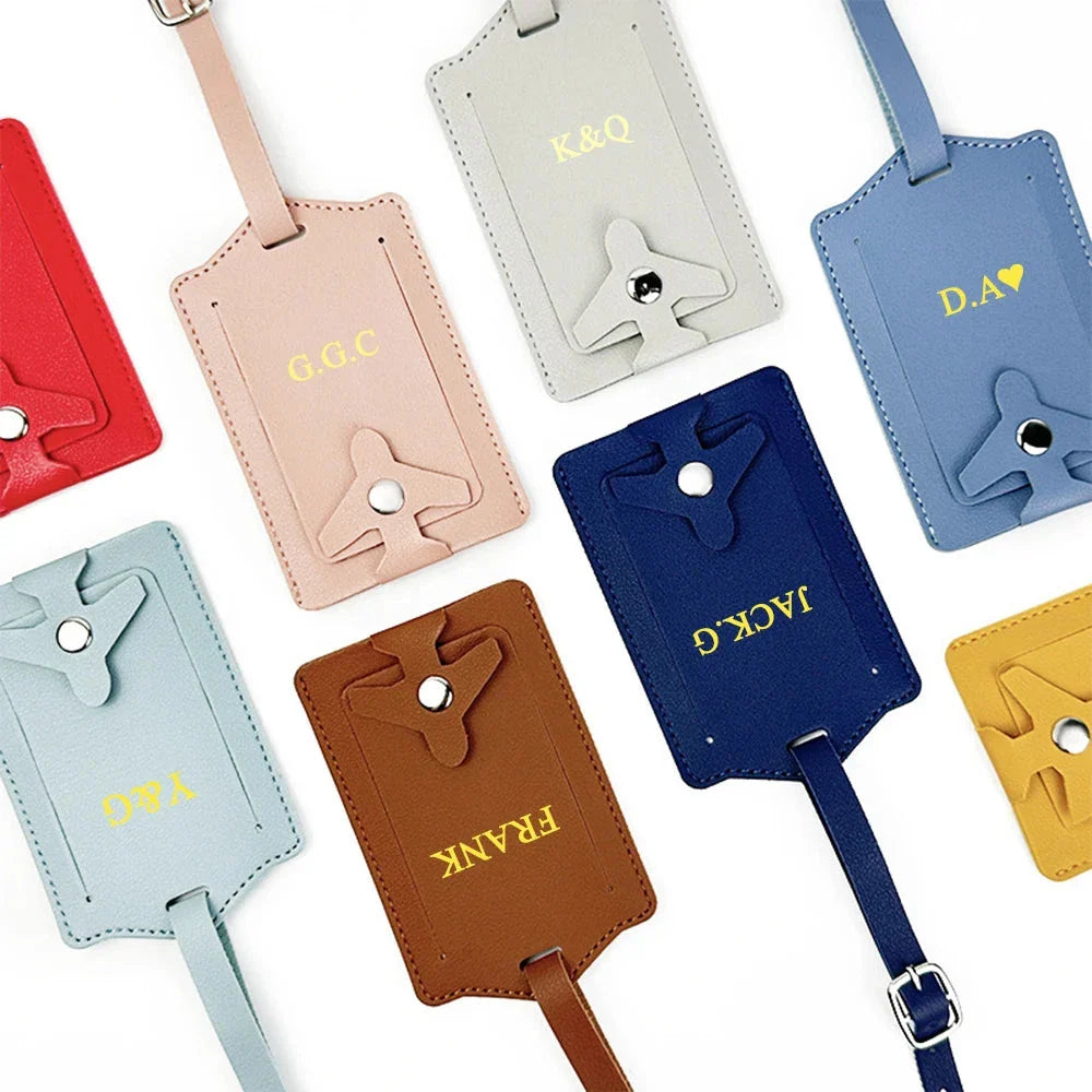 Étiquette turquoise accrochée à une valise, initiales dorées