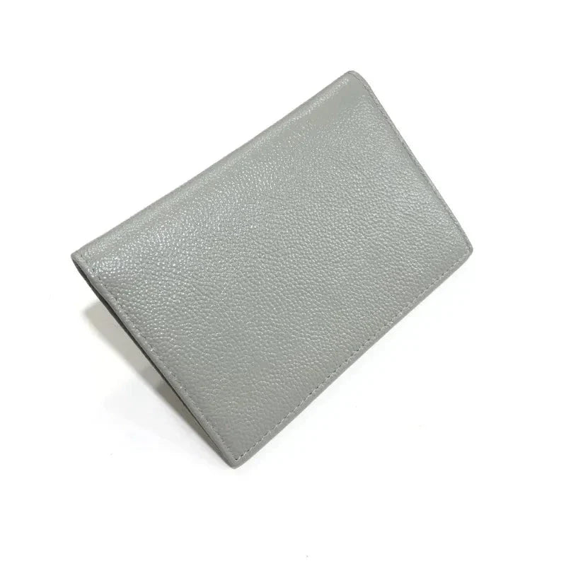 Étui passeport en cuir grainé gris, posé à plat