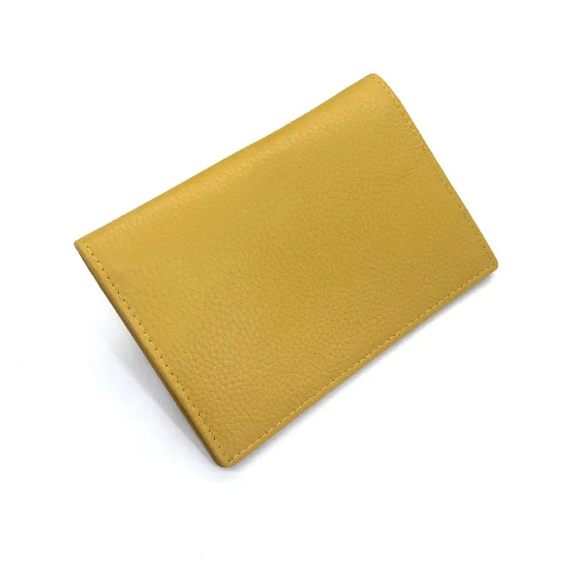 Étui passeport en cuir grainé jaune, posé à plat