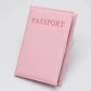Étui passeport rose, doux et élégant, posé sur une surface claire