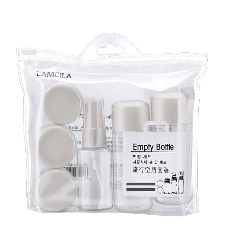 Kit de voyage avec flacons et pots gris dans une trousse
