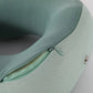 Coussin de voyage gris, boutons-pression visibles, tissu doux