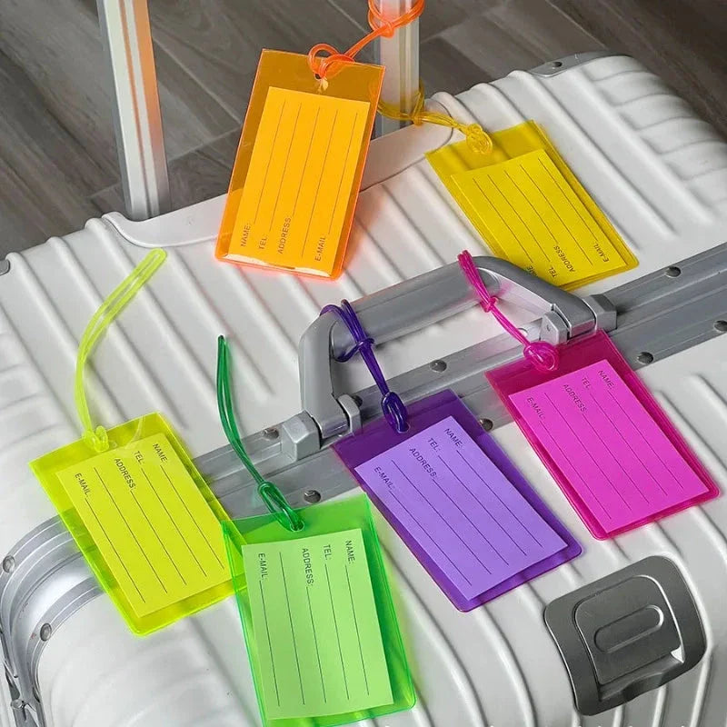 Porte-étiquette transparent attaché à une valise colorée
