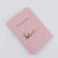Protège-passeport rose avec message doré sur la couverture