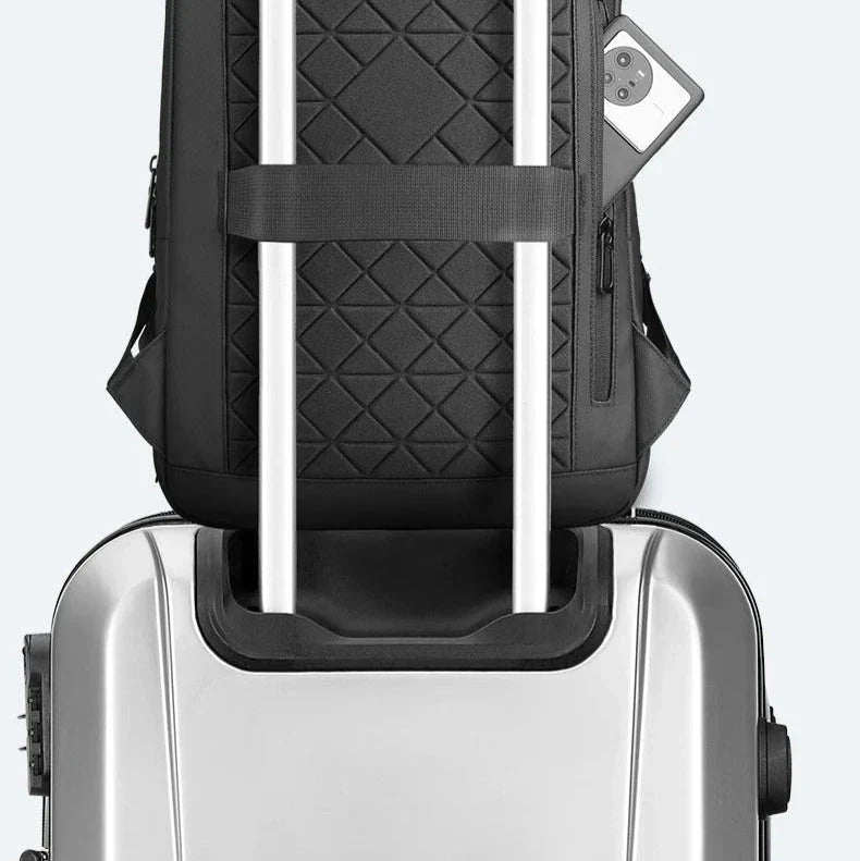 Sac à dos posé sur une valise, illustrant la sangle trolley