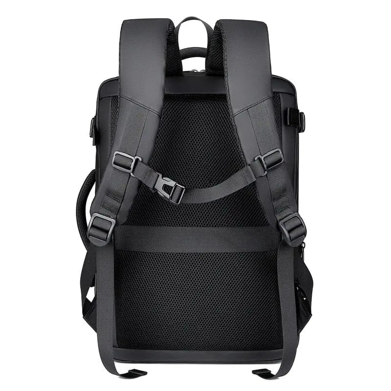 Sac à dos rigide posé sur une valise, sangle visible