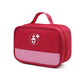 Trousse de voyage bébé rouge posée sur une surface blanche