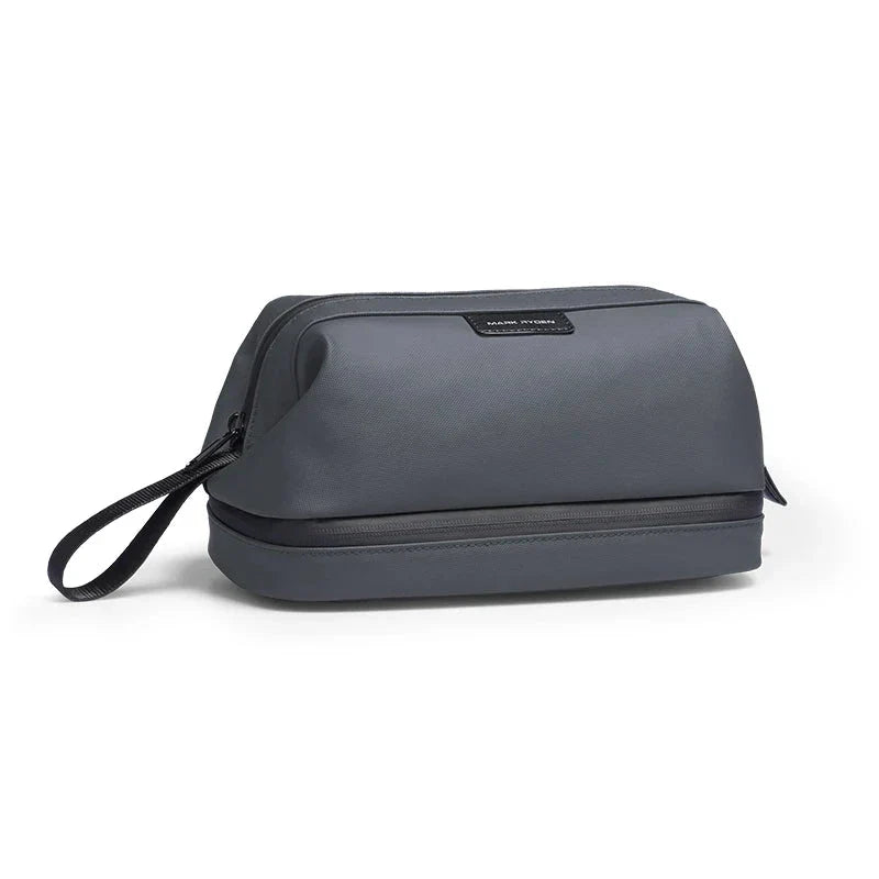 Trousse de toilette grise, compacte et rigide, posée sur une table