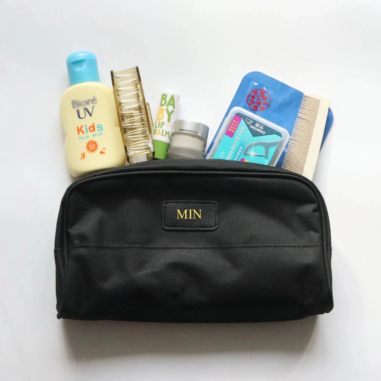 Trousse de toilette beige avec initiales dorées sur le devant