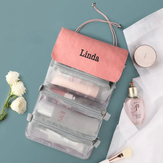 Trousse de toilette rose avec plusieurs compartiments visibles